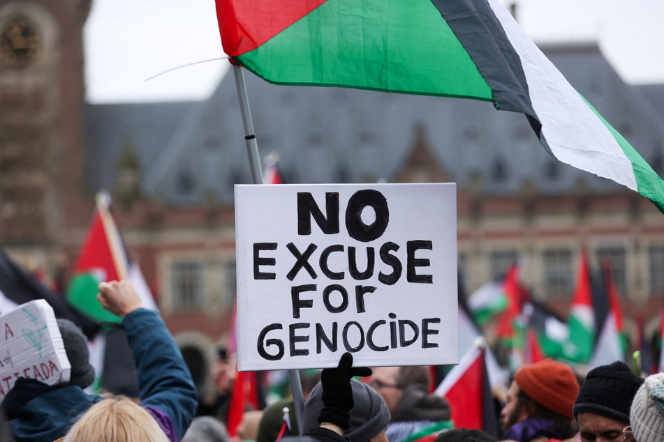 A person holds a sign reading "No Excuse for Genocide" near the International Court of Justice as judges hear South Africa's request for emergency measures to order Israel to stop its military actions in Gaza.