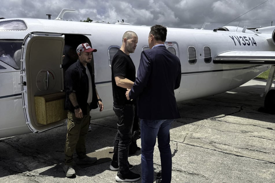 Special presidential envoy Richard Grenell (r.) greets US Air Force veteran Joe St. Clair (c.) upon his release from Venezuelan custody.