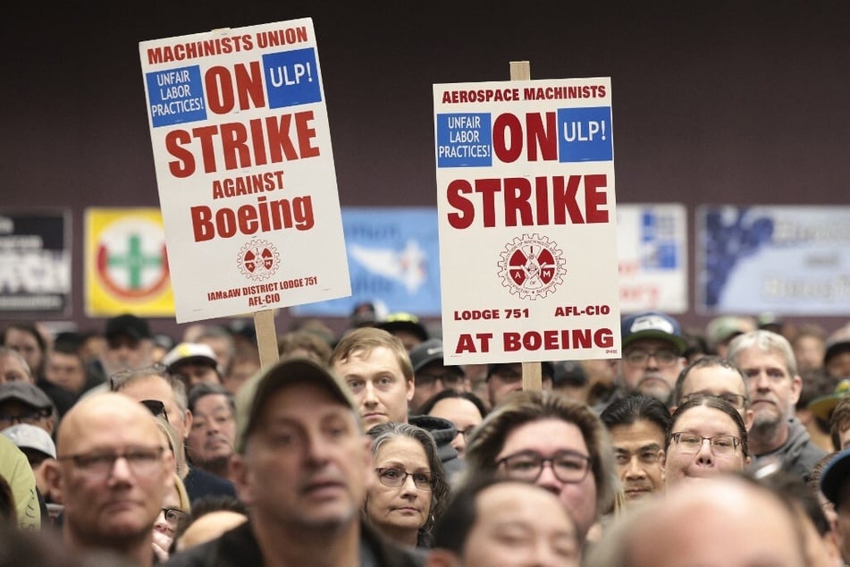 People hold signs during a strike rally for the International Association of Machinists and Aerospace Workers at the Seattle Union Hall in Washington.