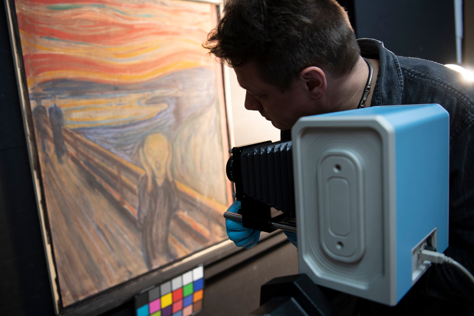Ein Mann richtet eine Infrarotkamera auf das Gemälde "Der Schrei" von Edvard Munch.