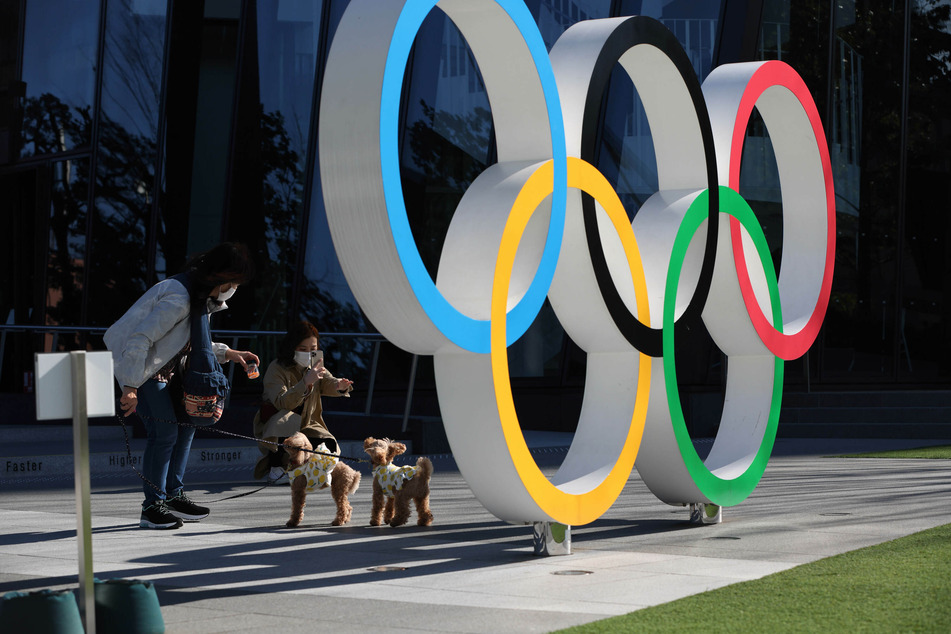 Eine Frau fotografiert Hunde an den Olympischen Ringen im Bezirk Shinjuku. Aufgrund der Corona-Pandemie dürfen dieses Jahr keine ausländischen Fans nach Japan reisen.