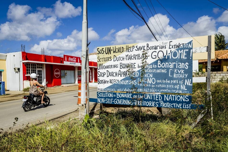 A protest sign along a road in Kralendijk calls for the reinstatement of Bonaire to the United Nations' Non-Self Governing Territories list.