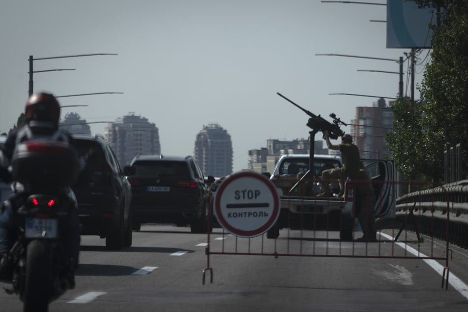 Ukrainische Soldaten bewachen während der massiven russischen Angriffe auf einer Stadtstraße den Himmel über Kiew mit einem Maschinengewehr.