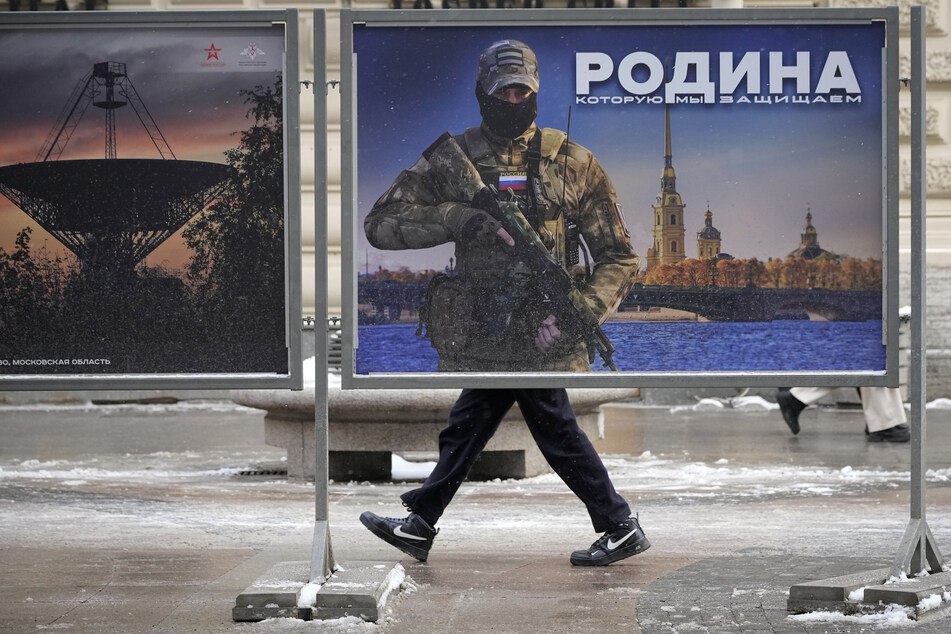 Das Bild eines russischen Soldaten mit der Aufschrift "Wir verteidigen das Vaterland" hängt in St. Petersburg. Nach Berichten über russische Kriegsverbrechen in der Ukraine hat Moskau inzwischen die Strafen wegen einer "Verunglimpfung" der eigenen Kämpfer deutlich verschärft.
