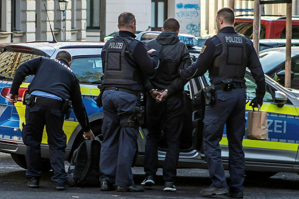 Polizisten führen den festgenommenen Einbrecher zum Streifenwagen. Am Freitag muss er zum Haftrichter.