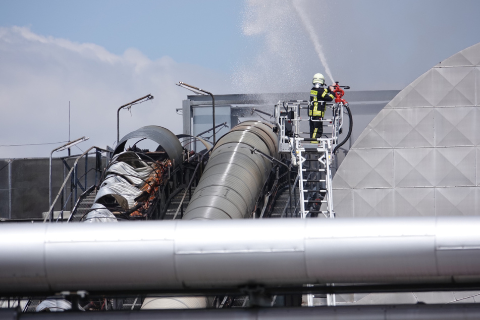 Ein Feuerwehrmann beim Löschen des Förderbands.