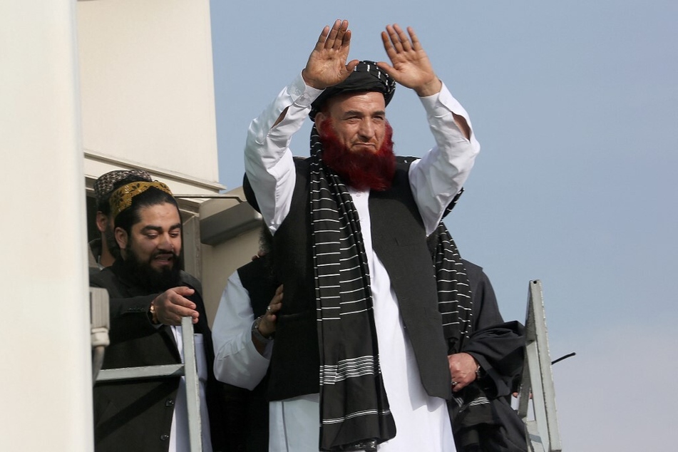 Abdul Karim raises his hands as he arrives at the Kabul airport in Afghanistan.