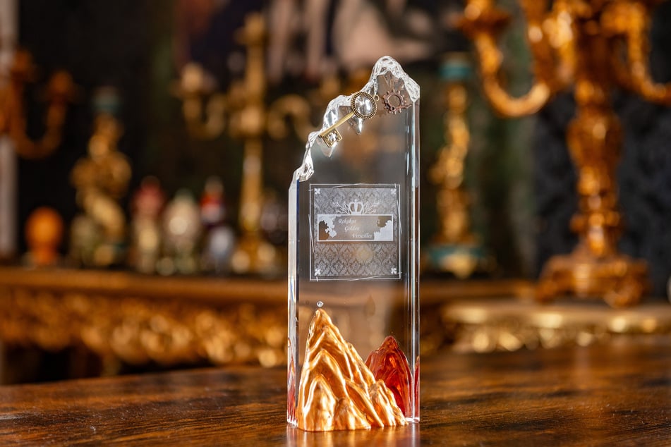 Der Award aus Glas spielt mit den goldenen Bergen auf Höhen und Tiefen im Leben an und will ermutigen.
