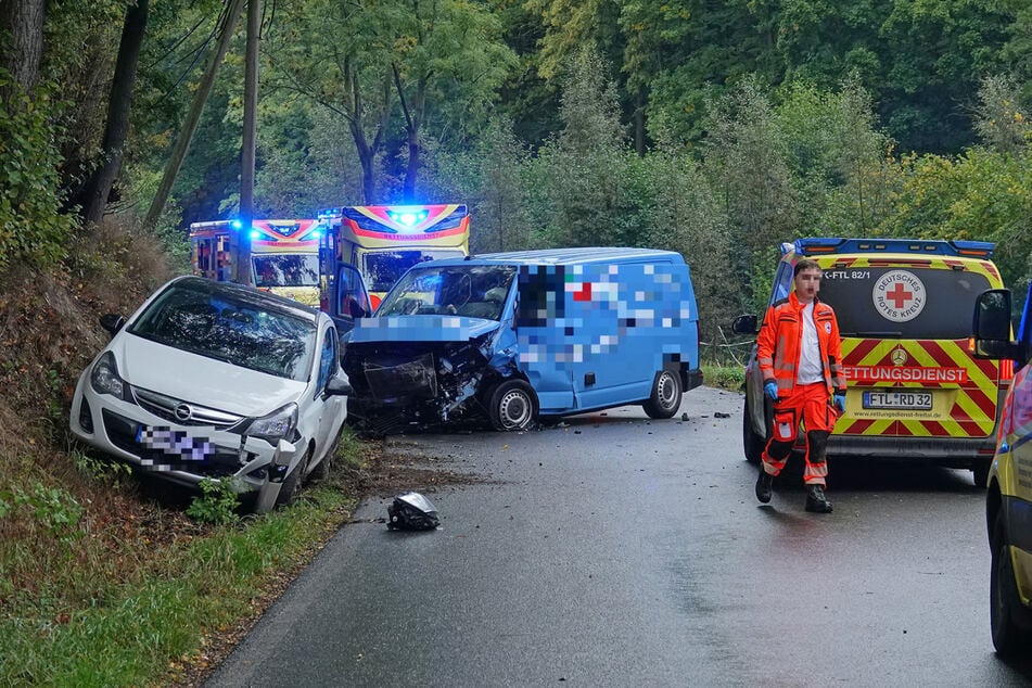 Rettungskräfte am Einsatzort. Schwerer Unfall auf der Wittgensdorfer Straße mit drei Autos. Im Hintergrund: der beteiligte Kleintransporter sowie der Opel Corsa.