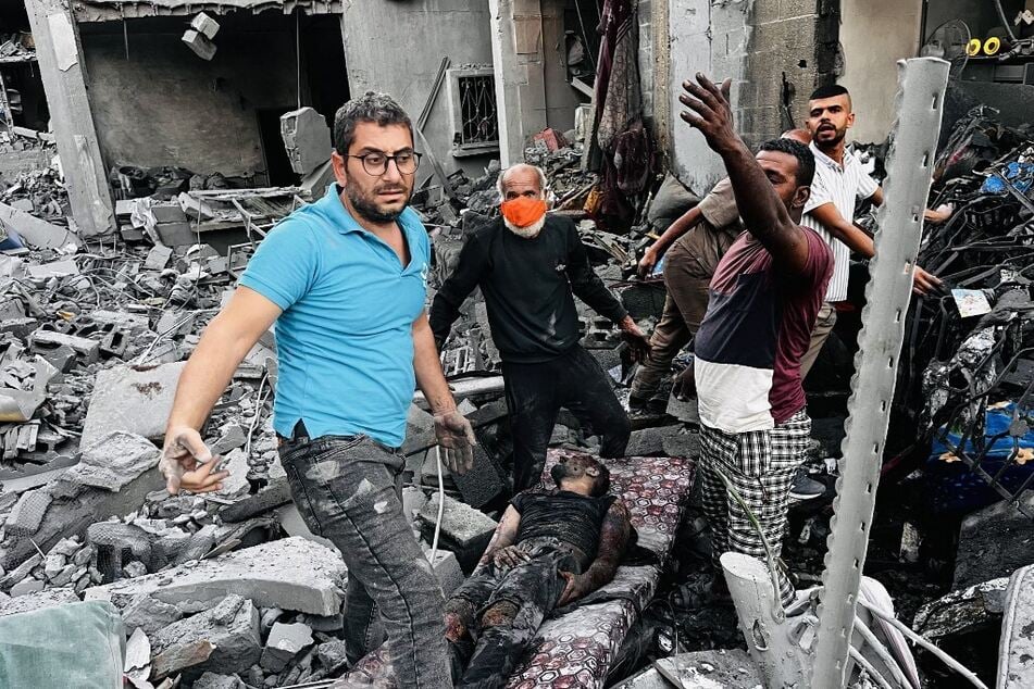 Palestinians help a wounded man at the site of an Israeli strike in Jabalia in the northern Gaza Strip.