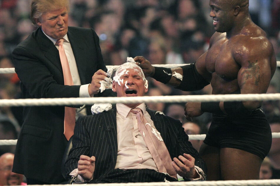 Trump previously appeared in the wrestling ring alongside Linda McMahon's husband, Vince (c.), as part of a staged feud.