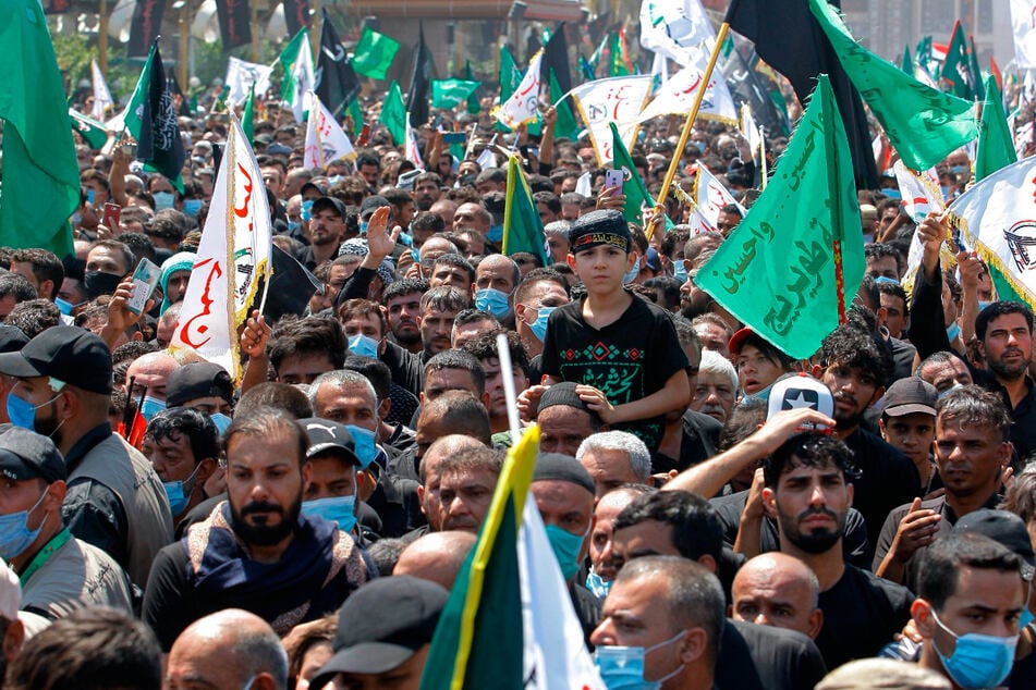 Gläubige versammeln sich nur teilweise mit Mundschutz ausgerüstet während einer Zeremonie am Tages der Aschura vor dem heiligen Schrein des Imam Hussein. Jom Aschura ist der zehnte Tag des Muharram, des ersten Monats im islamischen Kalender, der den Tag markiert, an dem Husayn ibn Ali, der Enkel des islamischen Propheten Mohammed, in der Schlacht von Kerbala getötet wurde.