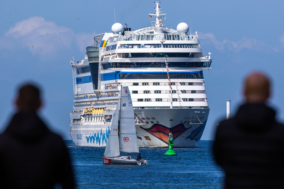 Rostock: Kreuzfahrtfans begrüßen die "Aidasol" beim Einlaufen in den Hafen.