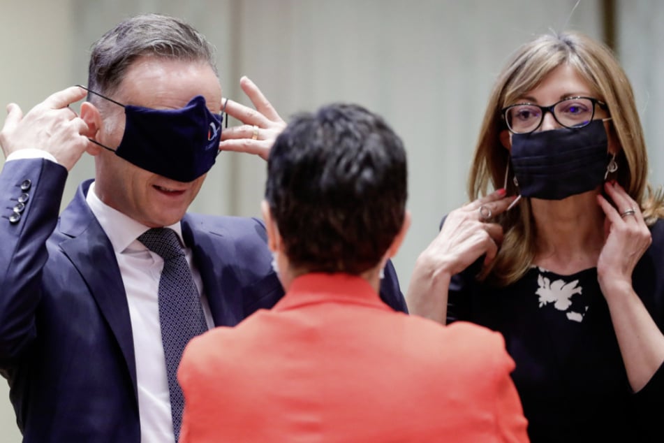 Heiko Maas (SPD,l), Bundesaußenminister, und Ekaterina Zharieva, Außenministerin von Bulgarien, ziehen Mundschutze vor einem Treffen mit den EU-Außenminster an.