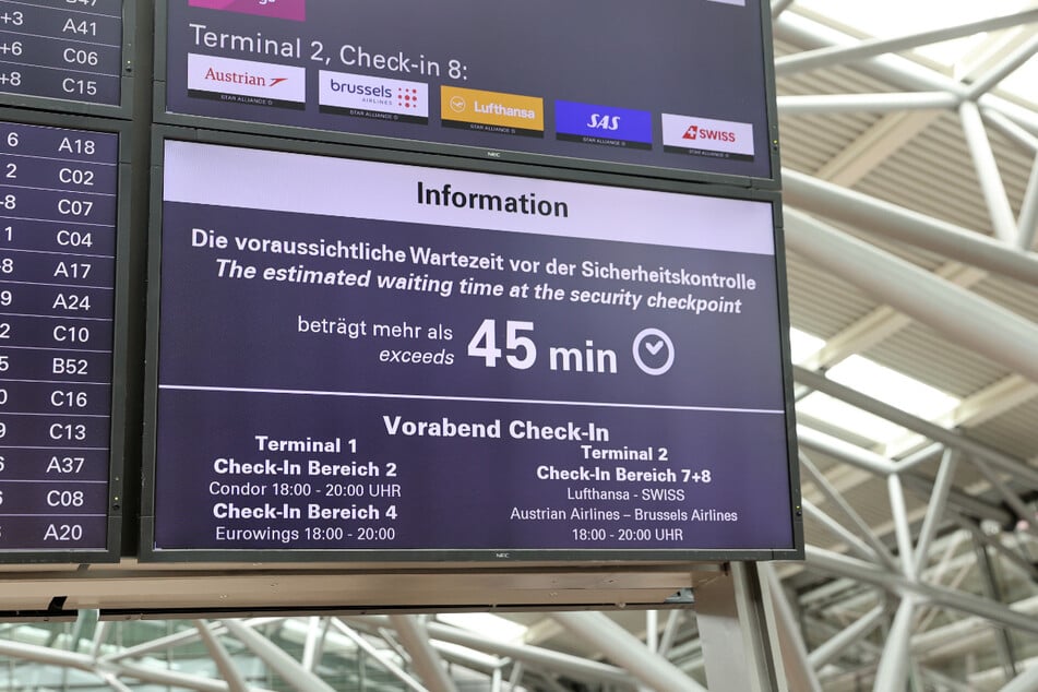 Anzeigetafeln informieren am Airport Hamburg, dass die Wartezeit vor den Sicherheitskontrollen fast eine Stunde beträgt.