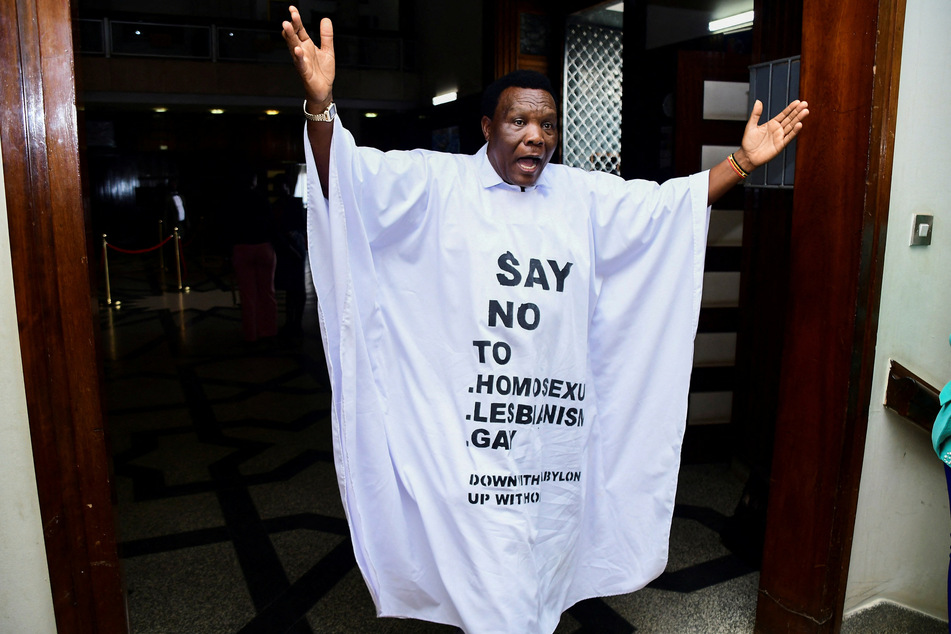 A Ugandan member of parliament displays homophobic messages ahead of a vote on a law criminalizing LGBTQ+ people.