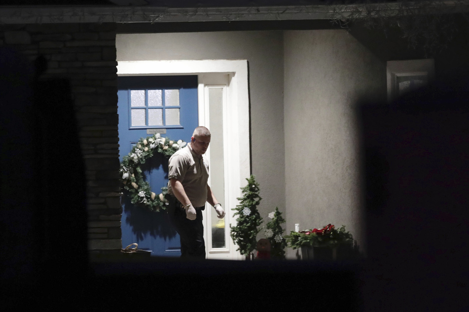 Ein Beamter der Strafverfolgungsbehörden steht neben der Eingangstür des betroffenen Hauses in Enoch.