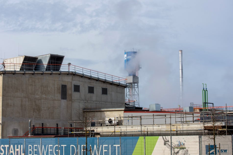Vor den Fabrikanlagen der Lechstahlwerke (LSW) hängt ein Transparent mit der Aufschrift "Stahl bewegt die Welt".
