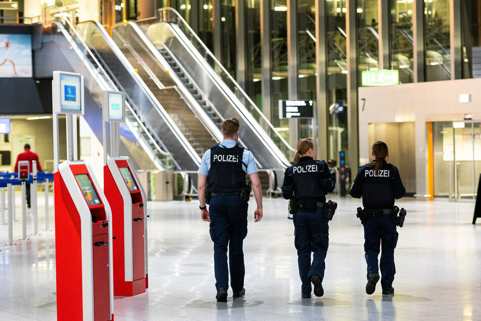Drei Polizisten gehen durch das Terminal 1 am Flughafen in Frankfurt/Main.