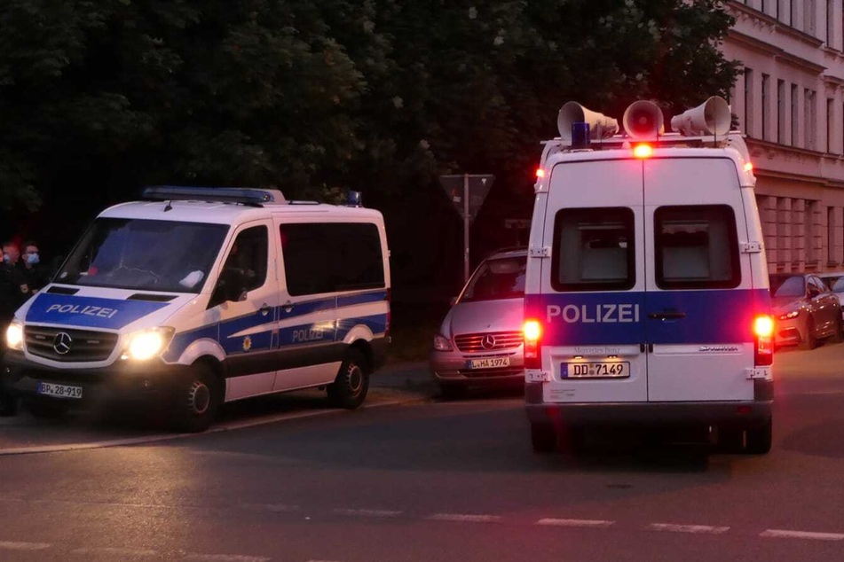 Rund um die Wurzner Straße sind zahlreiche Einsatzkräfte der Polizei unterwegs, die per Lautsprecher zum Anmelden der Versammlung aufrufen.