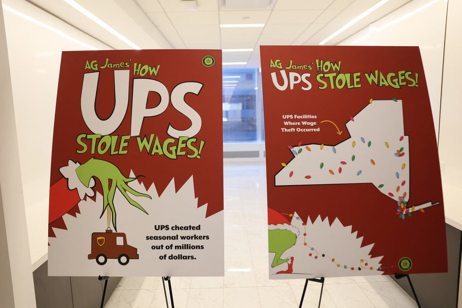 A Grinch-themed poster reading "AG James' How UPS Stole Wages!" is pictured during a press conference at the office of the attorney general in New York City on December 15, 2025.