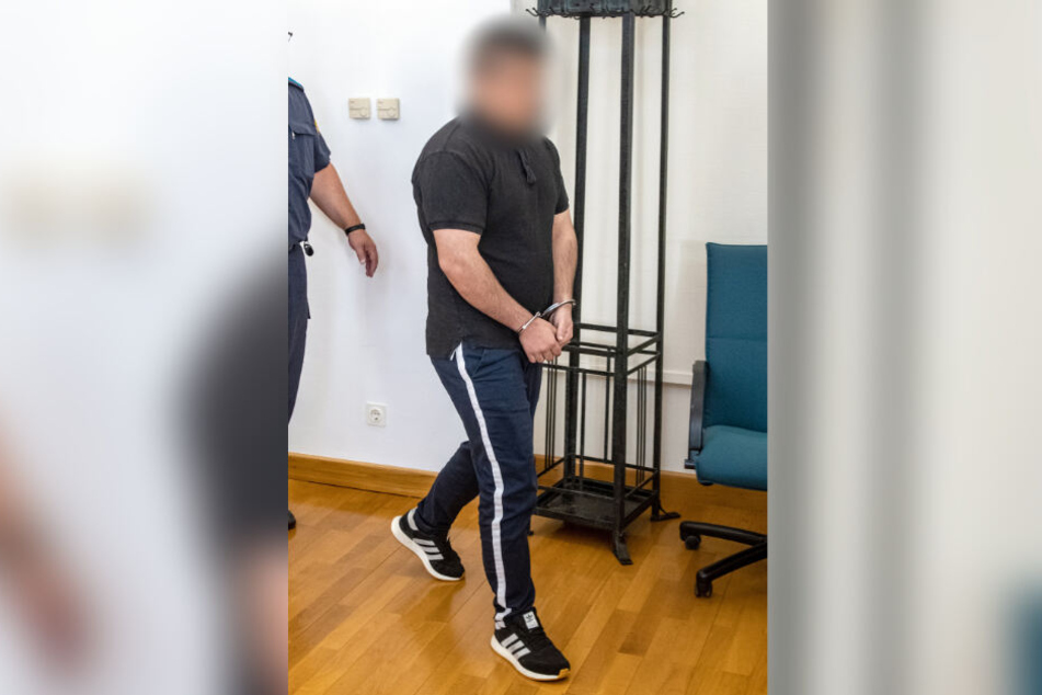 Der Angeklagte kommt in Handschellen in den Verhandlungssaal des Landgerichts.