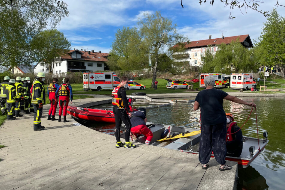 Einsatzkräfte der Feuerwehr und Rettungsdienste stehen an einem Badesee bei Sulzberg im Oberallgäu. Ein Kleinflugzeug mit vier Menschen an Bord ist kurz nach dem Start in den See gestürzt.