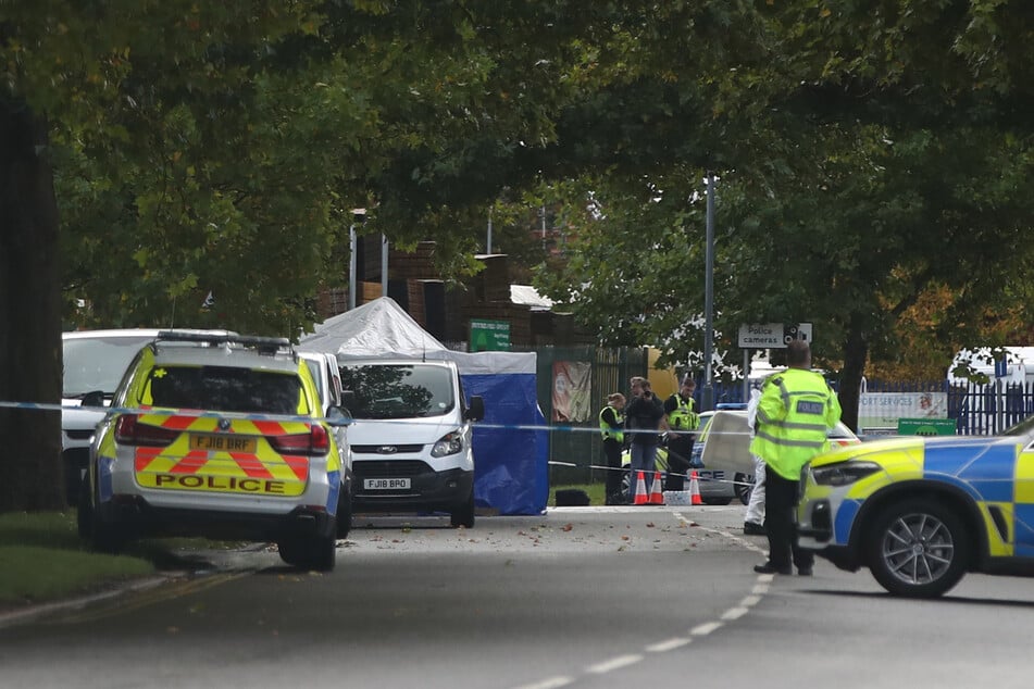 Nach den tödlichen Schüssen auf den bewaffneten Mann sichern zahlreiche Beamte die Polizeistation in Derby.