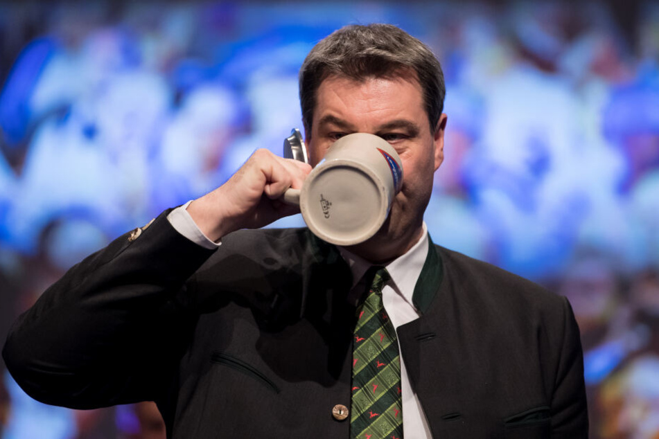 Markus Söder (CSU), damaliger Finanzminister von Bayern und amtierender Ministerpräsident, trinkt beim politischen Aschermittwoch der CSU nach seiner Rede ein Bier auf der Bühne. (Archivbild)