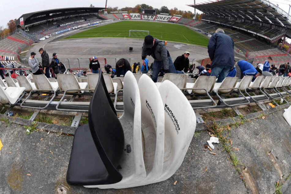 Zum Abschied des alten Stadions: Fans des Fußball-Drittligisten Karlsruher SC demontieren im Wildparkstadion Karlsruhe Sitzschalen.