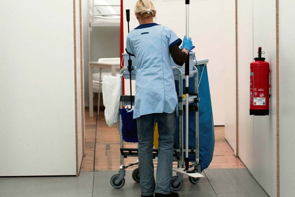 Eine Putzfrau schiebt ihren Wagen über einen Klinikflur. In der Gebäudereiniger-Branche kündigt sich ein harter Arbeitskampf an.