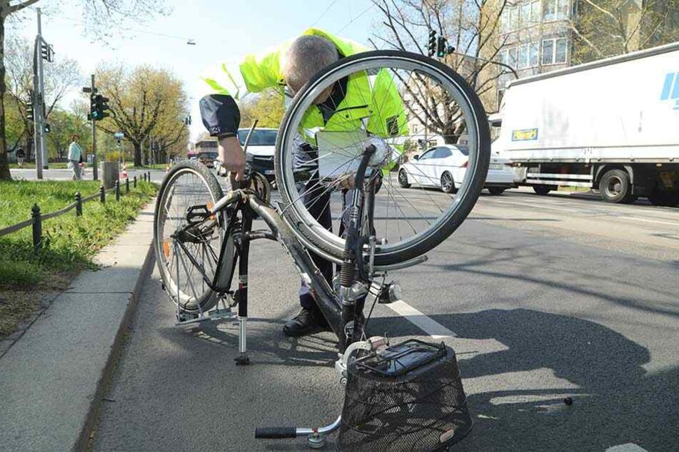 Der Polizist untersucht das verunfallte Fahrrad.