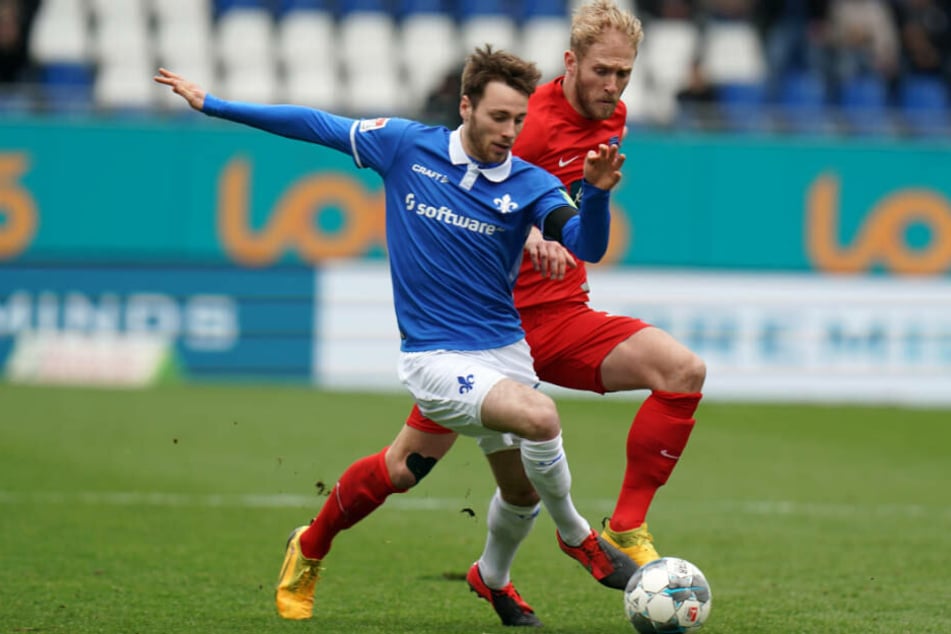 Darmstadts Matthias Bader (l) und Heidenheims Sebastian Griesbeck kämpfen um den Ball: Die Lilien hatten das Geschehen in der ersten Halbzeit vollkommen im Griff.