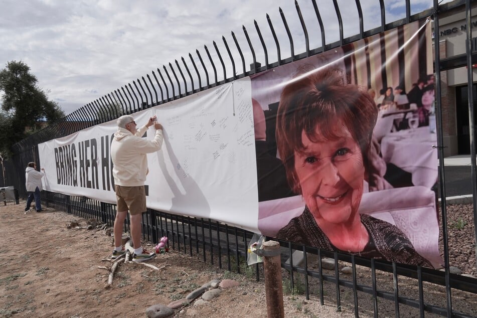 Ein Banner mit der Aufschrift "Bringt sie nach Hause" und einem Bild von Nancy Guthrie (84) prangt an einem Geländer.