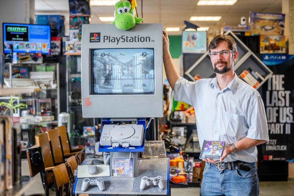 Ladeninhaber Robert Wolf (40) neben der ersten Playstation von 1995, die zum Spielen einlädt.