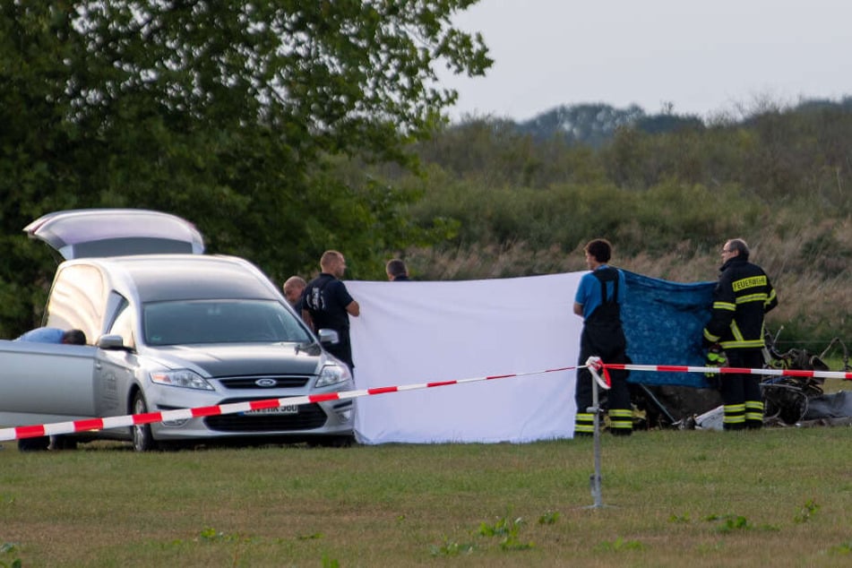 Die Leiche des tödlich verunglückten Piloten wird nach dem Absturz von einem Kleinflugzeug auf einem Feld zwischen dem Ortsteil Badingen und Gransee in eine Bestattungswagen verladen.