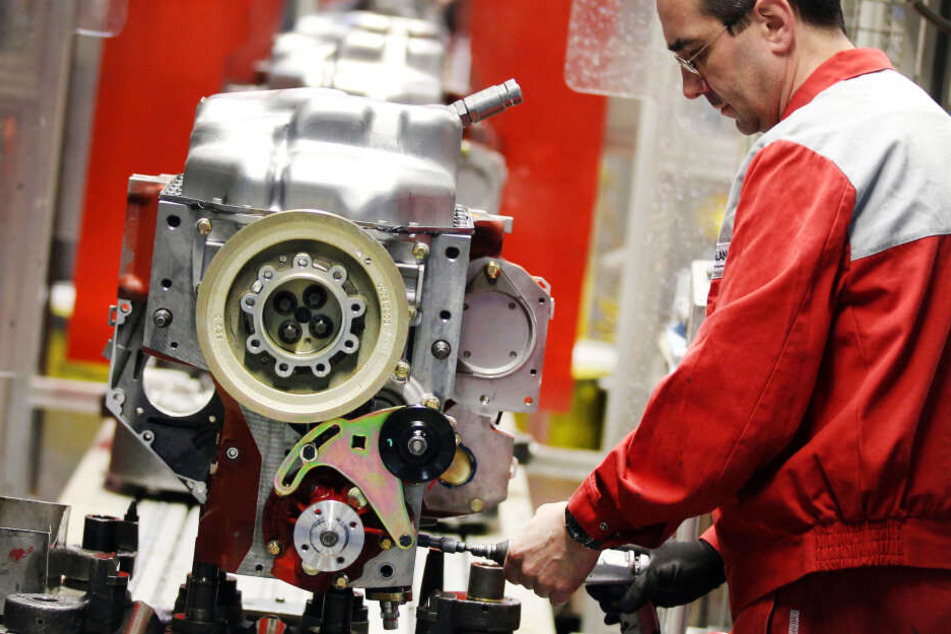 Ein Mitarbeiter der Deutz AG arbeitet an einem Dieselmotor.