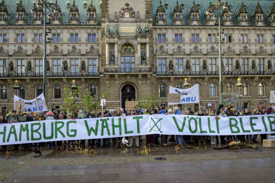 Teilnehmer einer Nabu-Aktion zum Erhalt des Vollhöfner Waldes protestieren vor dem Rathaus.