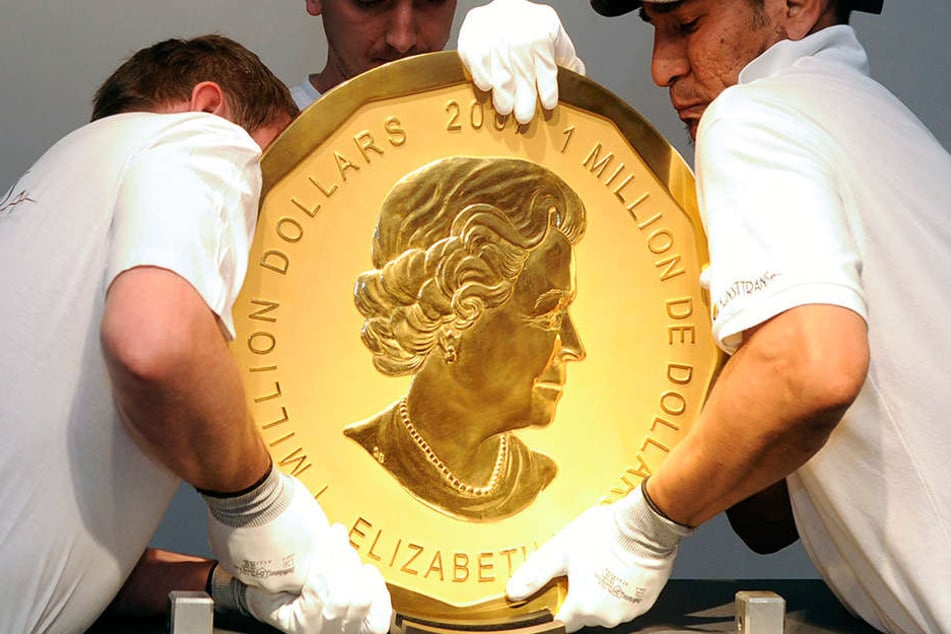 Mitarbeiter heben die 100 Kilo schwere Münze an ihren Platz. Das Bild zeigt ein Exemplar in Wien.