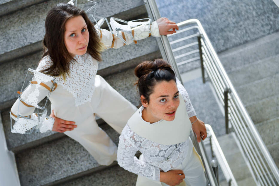 Die Modedesign-Studentinnen Pauline Kuhn (l.) und Juliane Mann tragen zwei Outfits mit Stickereien aus Plauener Spitze ihrer Kommilitoninnen Thuy Tien Phan (linker Entwurf) und Anna Reichardt.
