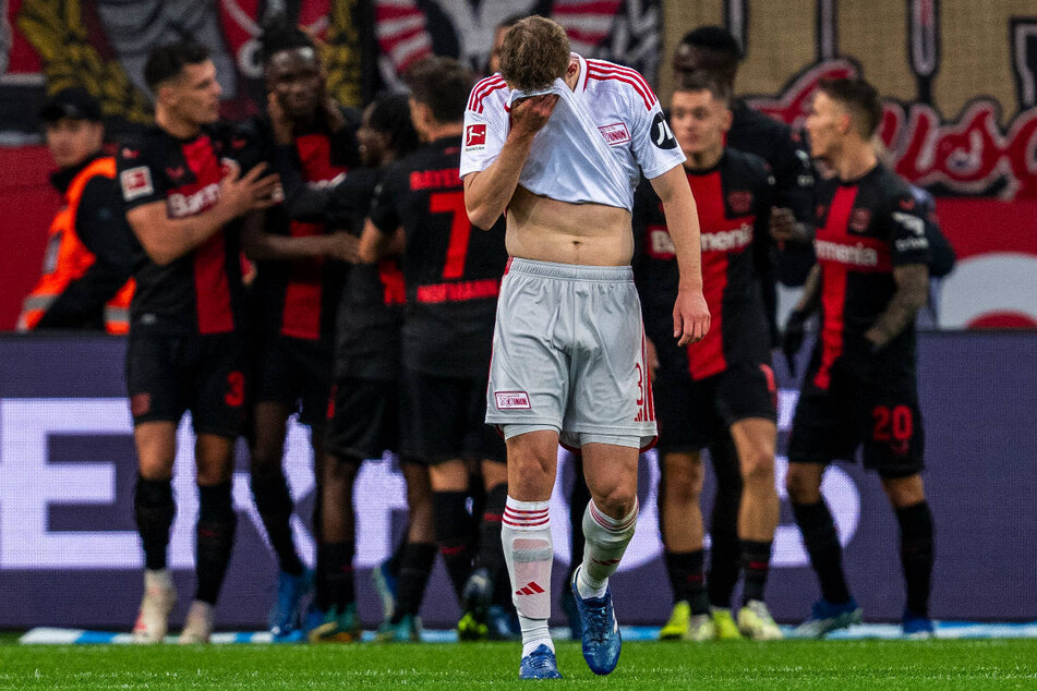 Während die Bayer-Kicker im Hintergrund das 2:0 feiern, zieht Unions Abwehrspieler Paul Jaeckel enttäuscht von dannen.