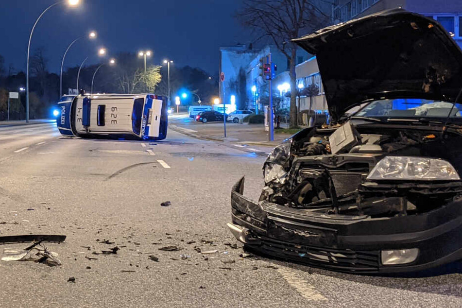 Die Front des Kombi wurde stark beschädigt, im Hintergrund liegt der Wagen der Bundespolizei auf der Seite.
