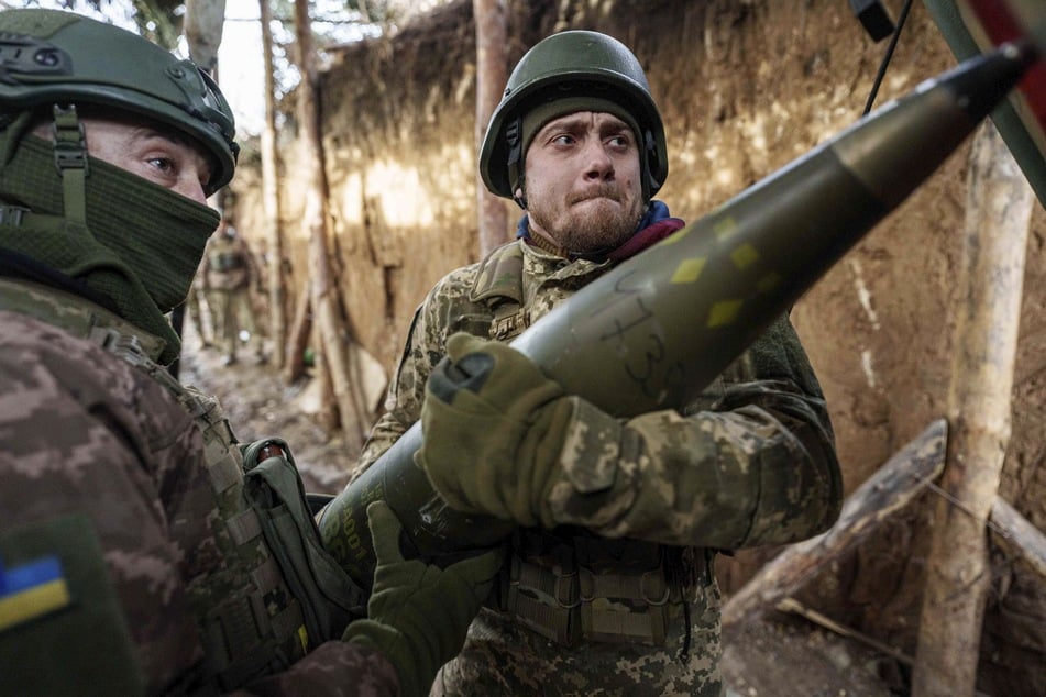 Urainische Soldaten laden Munition in eine Panzerhaubitze "Bohdana", bevor sie auf russische Stellungen an der Frontlinie in der Region Donezk schießen.