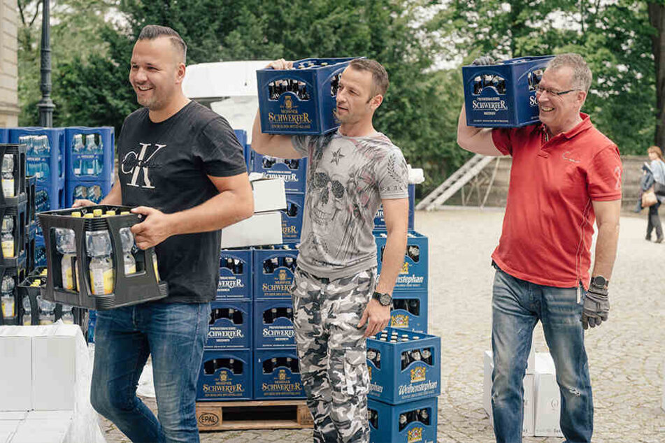 Lars Hauptvogel (31, v.l.), Sebastian Brohst (37) und Burkhard Hille (50) schleppen Getränkekästen ins Schloss Albrechtsberg. Eine Sackkarre darf aus Denkmalschutzgründen nicht benutzt werden.