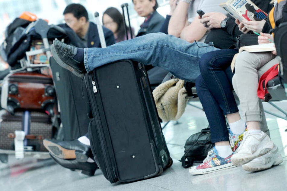 Passagiere warten am Flughafen mit ihrem Gepäck. Wer kein Auge auf seinen Koffer hat, hat schnell das Nachsehen, wie die Polizei nun berichtete. (Archivbild)