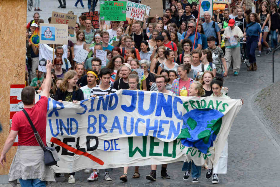 Teilnehmer einer Fridays for Future-Demonstration halten ein Banner mit der Aufschrift "Wir sind jung, wir brauchen die Welt".