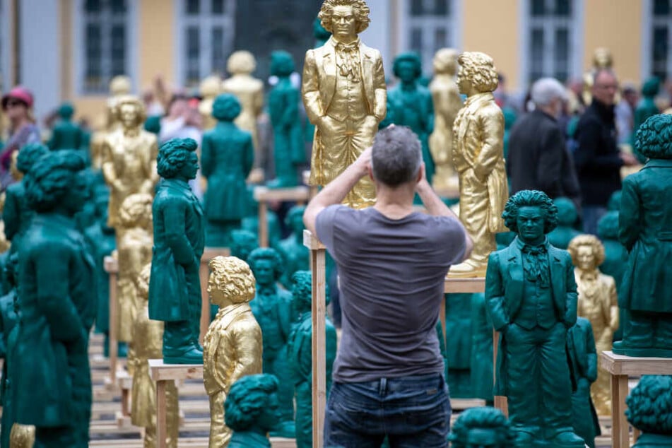 Ein Besucher fotografiert die Beethoven-Skulpturen in Bonn.