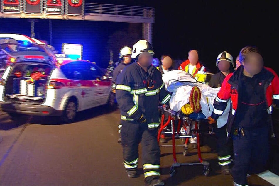 Helfer bringen einen Schwerverletzten zum Rettungswagen. Sie mussten zu Fuß zur Unfallstelle.