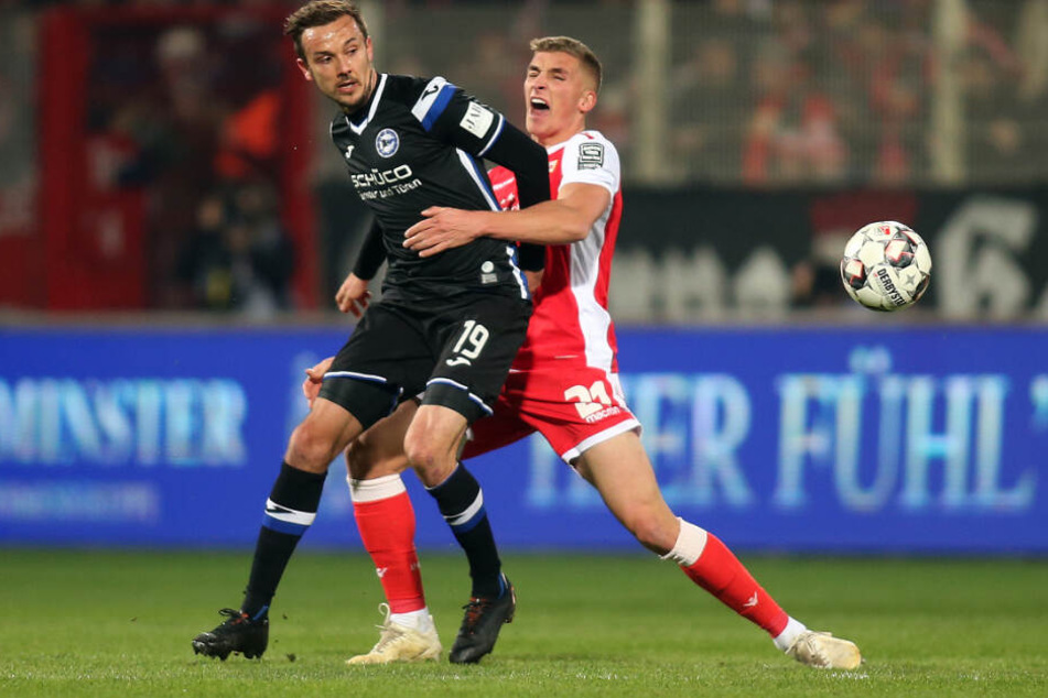 Manuel Prietl von Arminia Bielefeld (l) kämpft mit Berlins Grischa Prömel um den Ball.