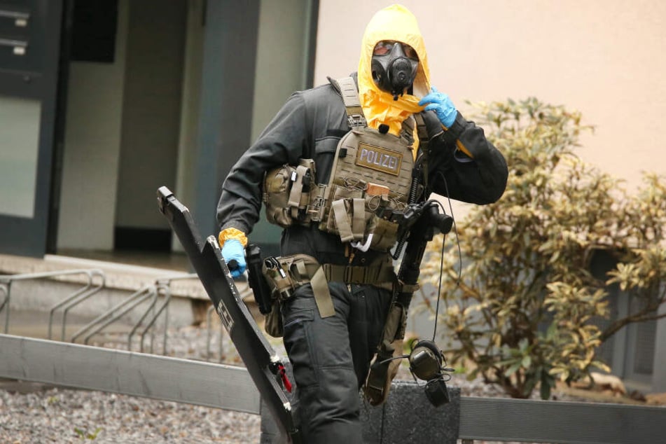 Ein Beamter des Spezialeinsatzkommandos läuft aus dem Haus.